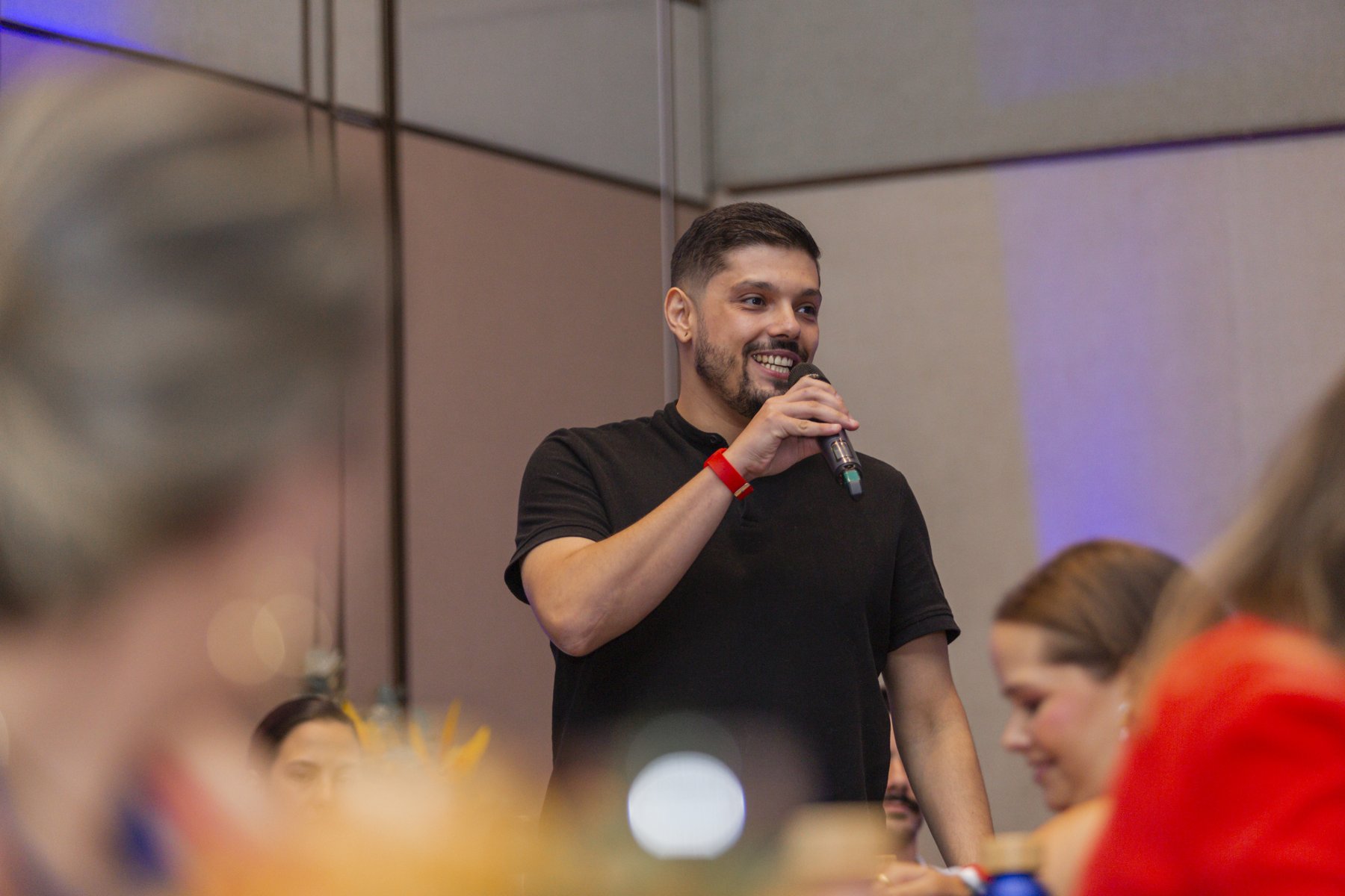 Victor Luporini falando ao microfone em um evento presencial